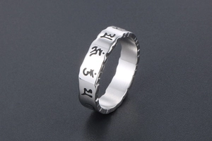 Detailed close-up of vintage stainless steel ring featuring engraved Buddhist mantras