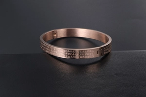 Macro shot of rose gold stainless steel bracelet with engraved Heart Sutra text details