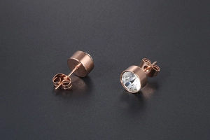 Macro view of rose gold titanium steel stud earrings with clear round sparkling crystals