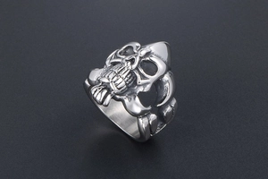 Detailed view of punk skull ring with intricate bone grip design in polished steel