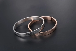 Detail of silver and rose gold heart sutra steel bracelets with brushed metal finish