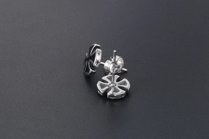 Macro shot of silver stainless steel cross earrings with black enamel and star engraving
