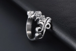 Macro shot of vintage titanium steel ring with cross and scrollwork pattern on black leather