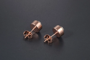 Macro side view of rose gold rose gold stud earrings with clear gemstone and butterfly back