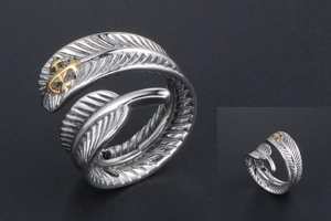 Détail de la bague plume vintage en argent avec emblème de croix dorée sur la pointe