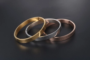 Detailed view of engraved scripture on gold, silver, and rose gold titanium steel bangles
