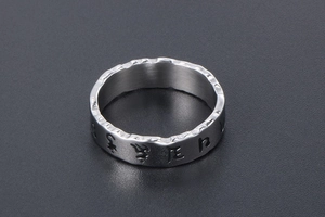 Macro shot of vintage men's stainless steel ring with Sanskrit engraving and brushed finish