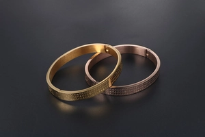 Close-up of gold Heart Sutra scripture engraved on polished stainless steel cuff bracelets