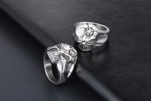 Macro shot of punk style stainless steel skull ring with intricate cross pattern engraving