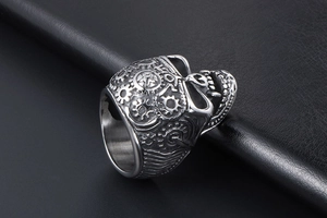 Macro shot of steampunk skull ring with mechanical gear textures on leather backdrop