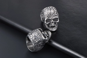 Macro detail of gothic punk skull rings with mechanical gears and antique silver finish