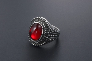 Detailed close-up of a vintage titanium steel ring with a large red oval gemstone inlay