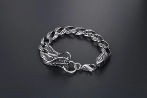 Détail d'un bracelet dragon en acier titane avec texture d'écailles et fermoir tête de dragon