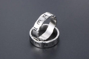 Macro shot of vintage titanium steel rings with Om Mani Padme Hum Sanskrit engraving