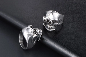 Macro view of two gothic skull rings with intricate bone textures on black leather