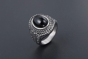 Macro detail of vintage men's steel ring with black oval stone and wheat carvings