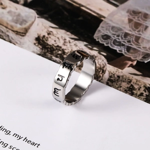 Vintage steel ring with Sanskrit engraving and irregular wave edges on a white background