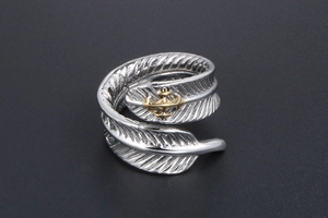 Vue macro d'une bague plume rétro en acier inoxydable avec emblème de croix dorée