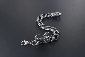 Détail d'un bracelet dragon vintage en argent avec tête de dragon et écailles