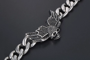 Macro detail of gothic skull with wings on a punk style stainless steel cuban chain
