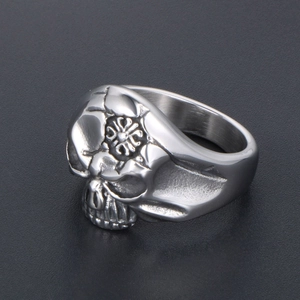Retro stainless steel skull ring with embossed patterns on dark textured background