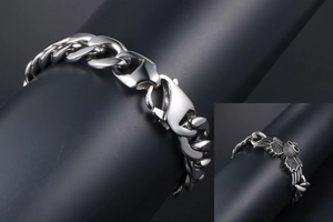 Detail of masculine stainless steel Cuban link bracelet with bat-shaped charm