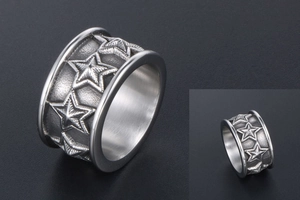 Detail of engraved star pattern on wide titanium steel ring with matte texture finish