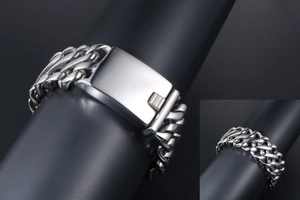 Macro shot of silver Cuban link stainless steel bracelet on black stand with side detail