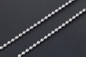 Macro shot of silver stainless steel ball chain necklace with polished bead details