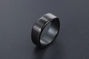 Macro view of a modern black square-shaped ring with a smooth semi-matte metallic finish