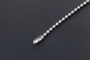 Macro detail of silver titanium steel bead chain with a secure cylindrical connector clasp