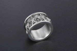 Close-up of a wide vintage titanium ring featuring embossed five-point star patterns