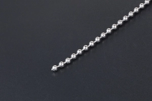 Close-up detail of silver bead chain necklace with polished metallic ball structure