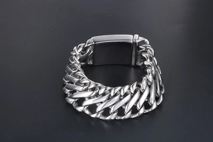 Macro shot of polished silver stainless steel Cuban link bracelet with rectangle clasp