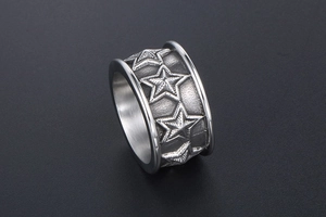 Macro view of wide silver ring with embossed five-point star and vintage finish details