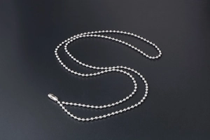 Close-up of silver stainless steel ball chain necklace with cylindrical connector clasp