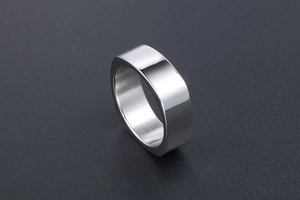 Detail of minimalist silver ring showing high-polished mirror finish and brushed inner band