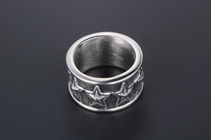 Close-up of wide titanium steel ring featuring continuous embossed five-star pattern