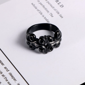 Detail of vintage hollowed-out titanium steel ring with black floral engraved patterns