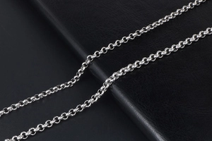 Dettaglio di una catena rolo da uomo in acciaio inossidabile argento su pelle nera