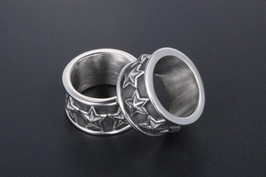 Macro view of matte silver stainless steel rings with detailed five-star relief pattern