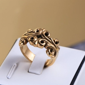 Macro shot of gold vintage engraved band ring featuring intricate floral relief patterns
