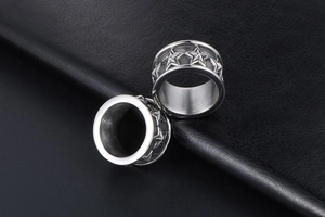 Detail of silver stainless steel flesh tunnels with engraved five-point star patterns