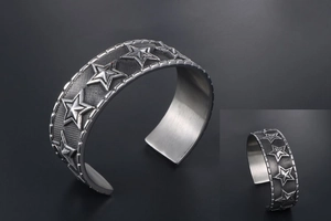 Macro view of retro star embossed punk cuff bracelet with textured mesh background