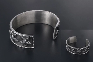 Close-up of vintage wide cuff bracelet featuring 3D star embossing and punk mesh texture