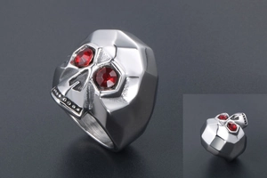 Close-up of gothic skull ring with geometric facets and striking red gemstone eyes
