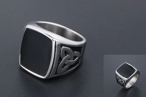 Gros plan détaillé d'une bague pour homme en acier titane argenté avec émail noir et nœuds celtes