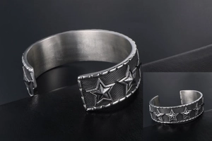 Close-up of vintage silver star bangle showing embossed stars and textured grid pattern