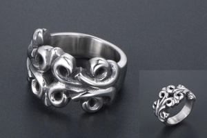 Detail of vintage silver titanium steel ring with intricate embossed punk scroll patterns