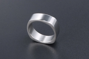 Macro side view of polished silver square ring with brushed metal inner texture